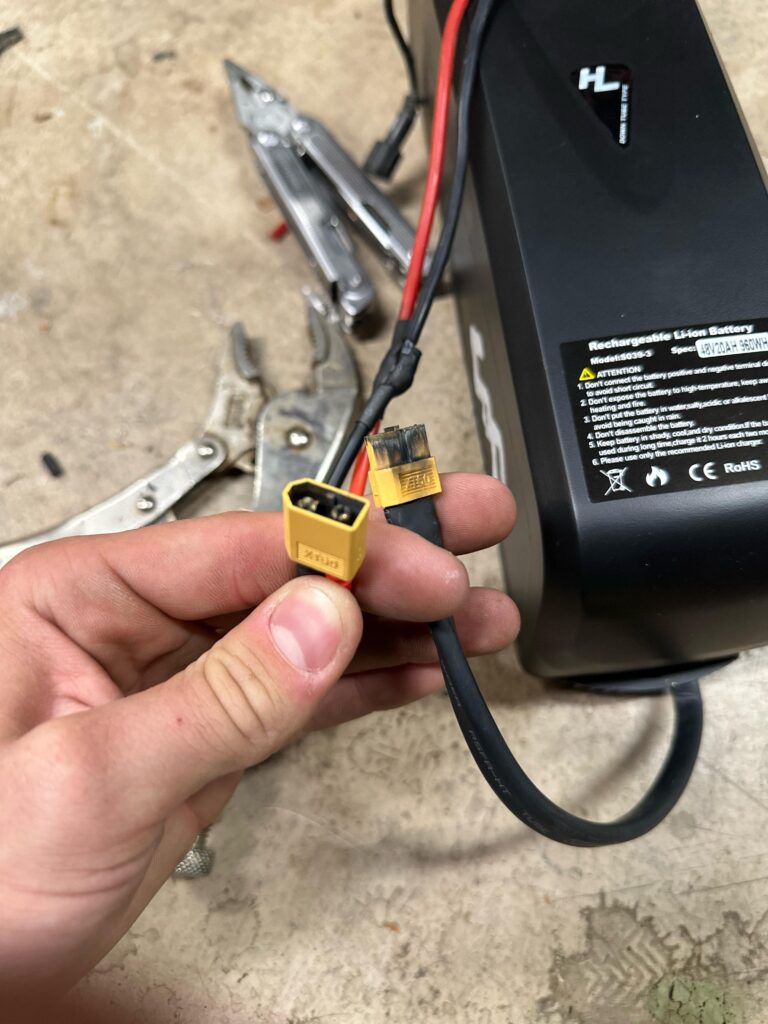 A person holding a burnt e bike charging connection