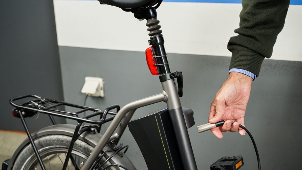 A person holding a charging switch to an e bike