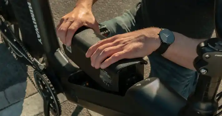 A top view of a person holding an e bike battery with both hands