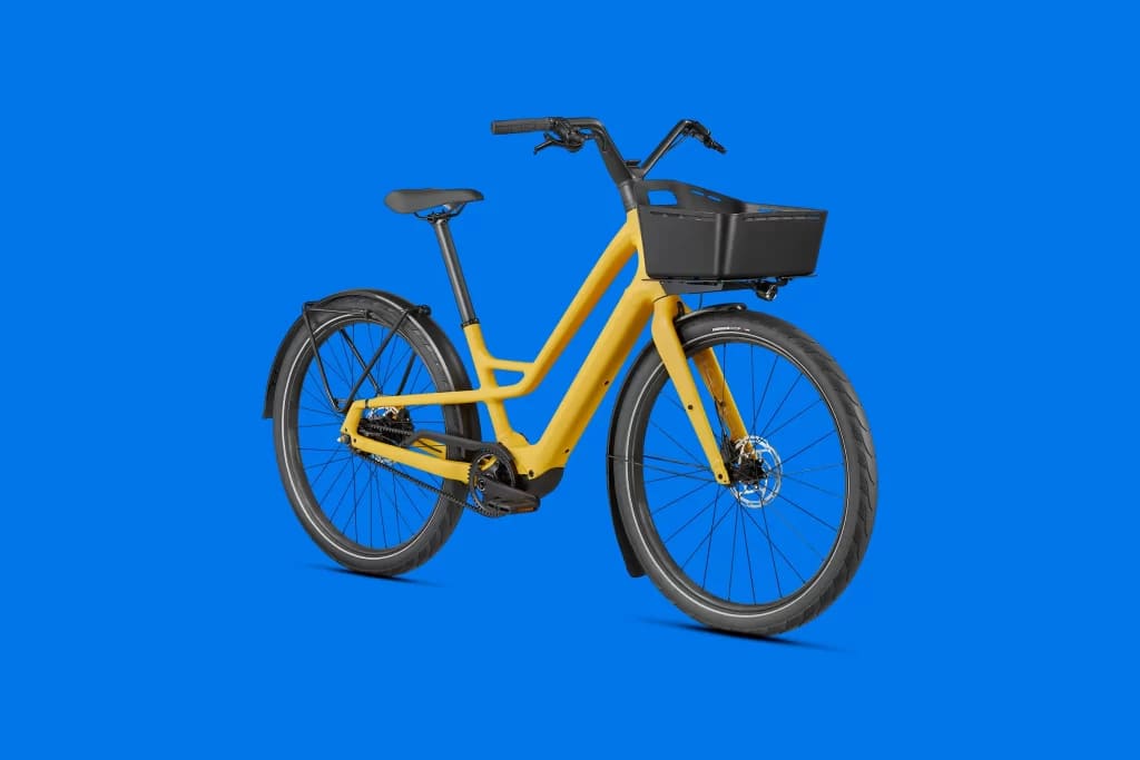 A view of a yellow Specialized Turbo Como SL Belt Drive Electric Bike with a blue background