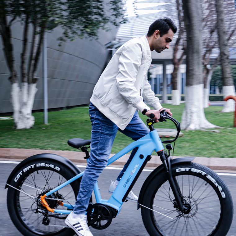 A guy riding an e bike paddling it slowly