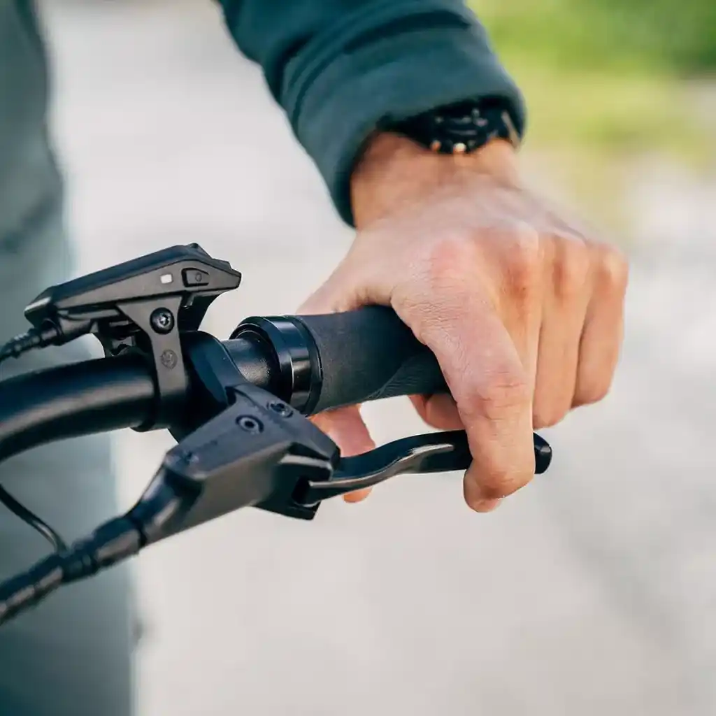 A person holding an electric bike brakes