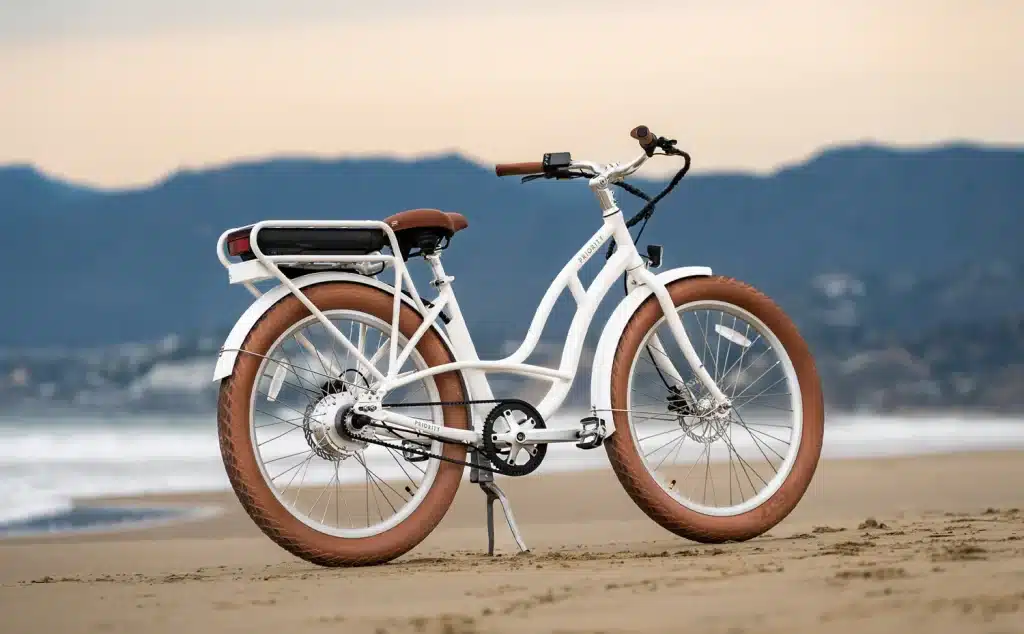 A white and brown electric bike on a beach shore