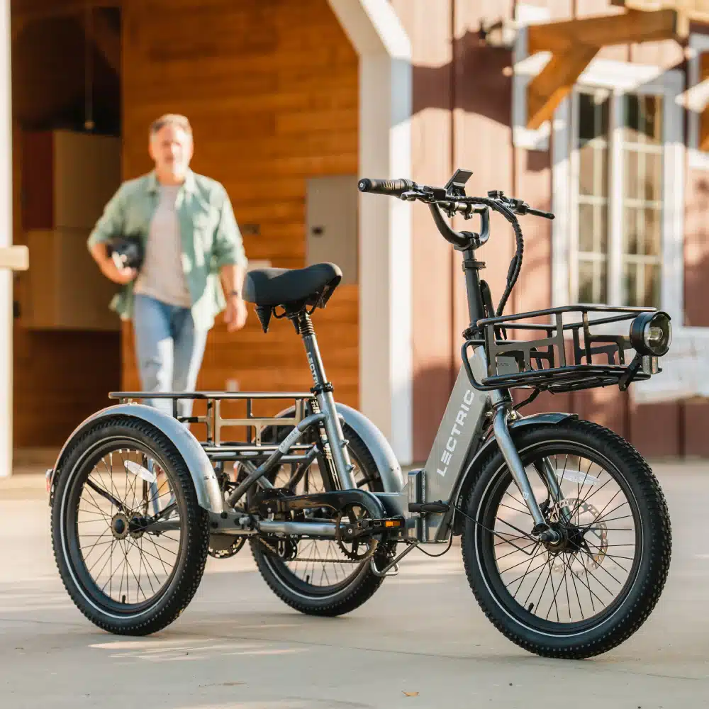 An electric bike parked with a front rack and a person in background