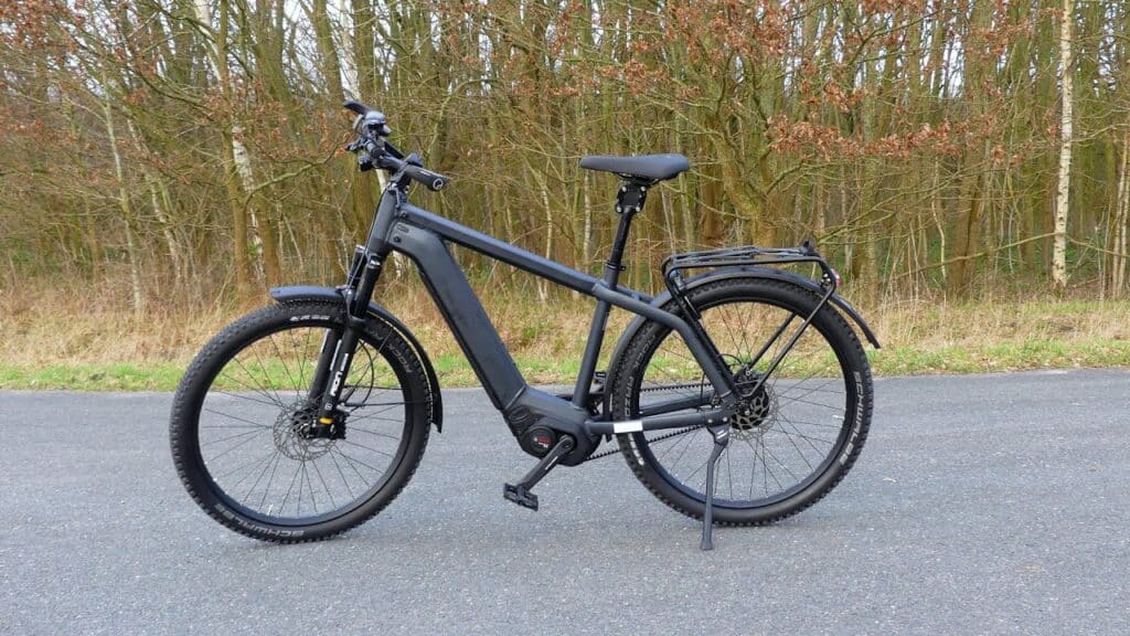 Riese Muller Charger commuter bike parked on a road in front of trees