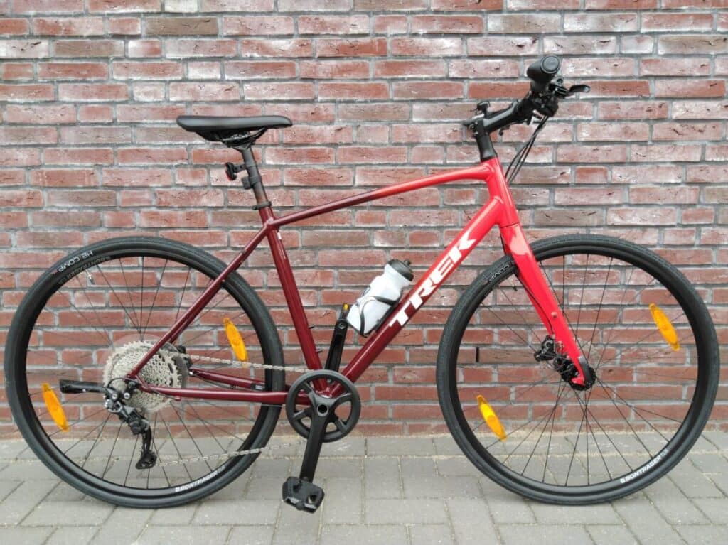 Trex FX bike parked on the roadside infront of a brick wall