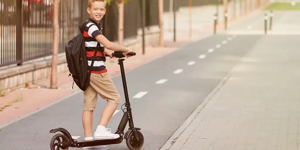 a boy going to school on his electric scooter