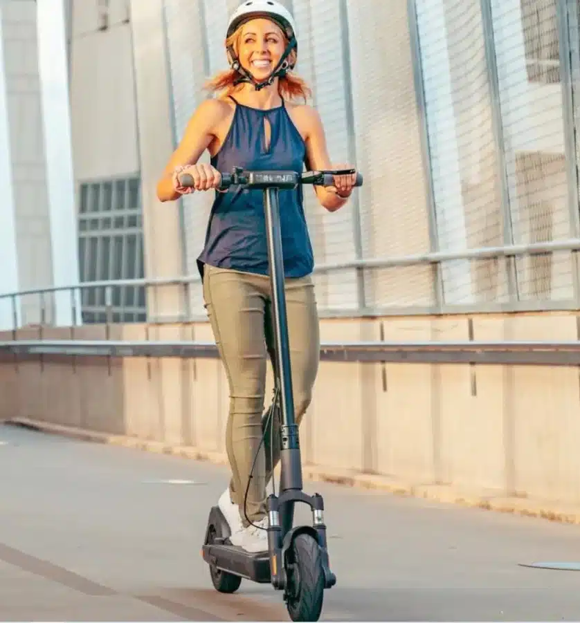 a girl driving her electric scooter on road