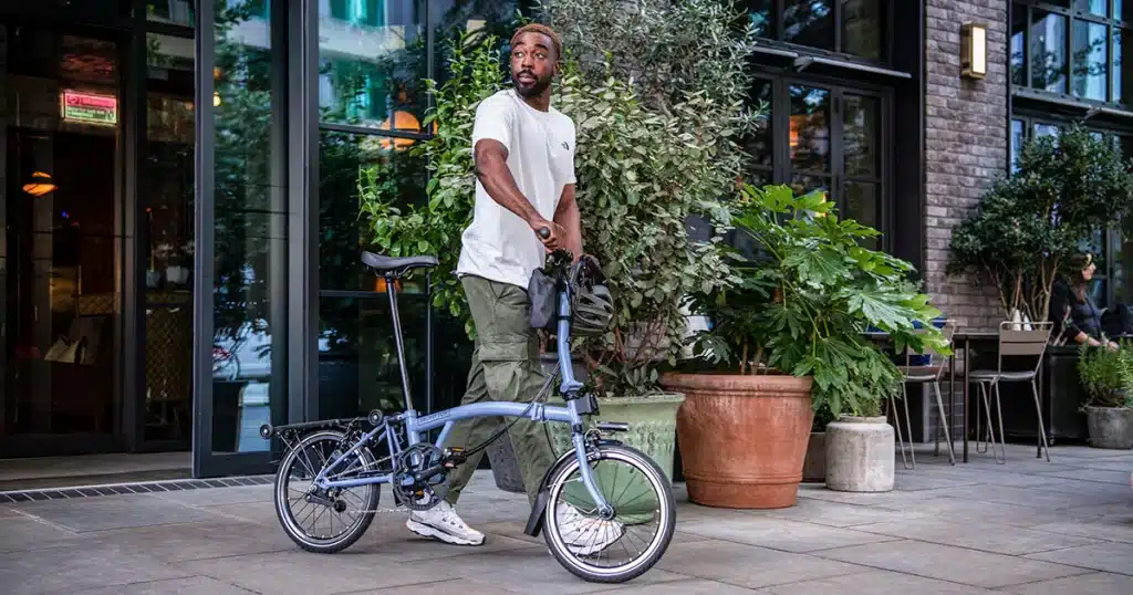 a man holding his The Brompton M L commuter bike