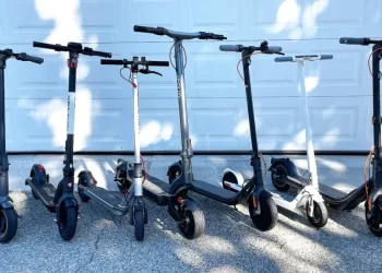 different models of electric scooters parked in a line