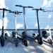 different models of electric scooters parked in a line