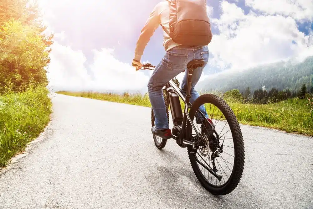 A backview of a guy riding bike on road