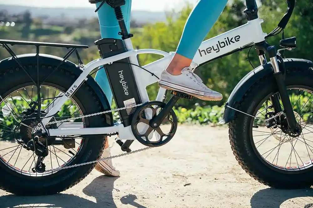 A lower view of a person paddling a e bike