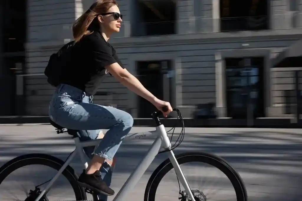 A side view of a girl riding an electric bike on a road