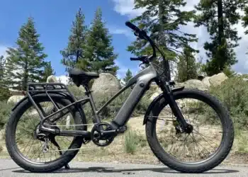 A view of a class ebike parked on a road alongside hills and trees