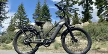 A view of a class ebike parked on a road alongside hills and trees