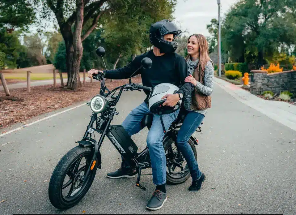 A view of a couple sitting on two seater electric bike