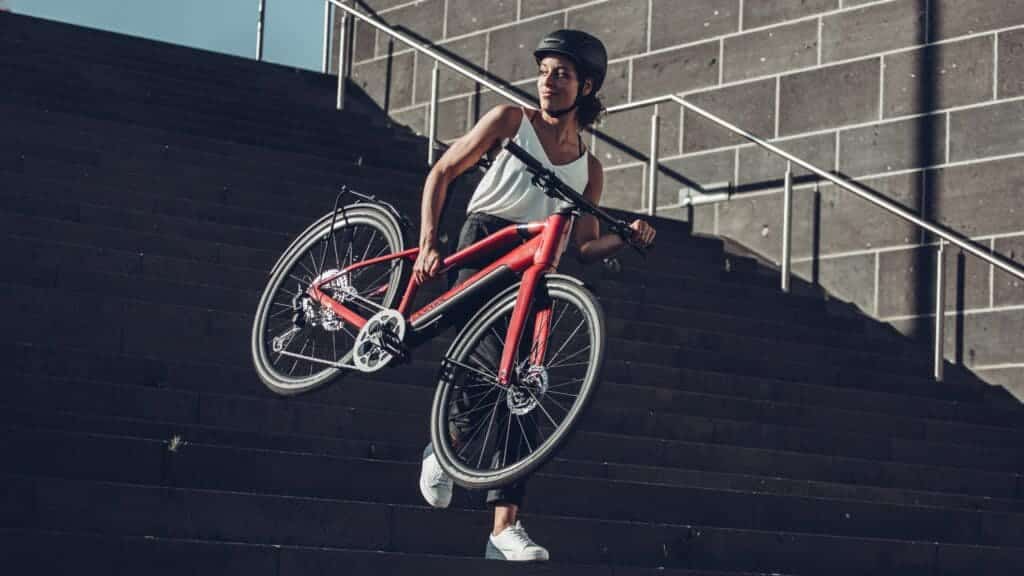 A view of a woman carrying an e bike