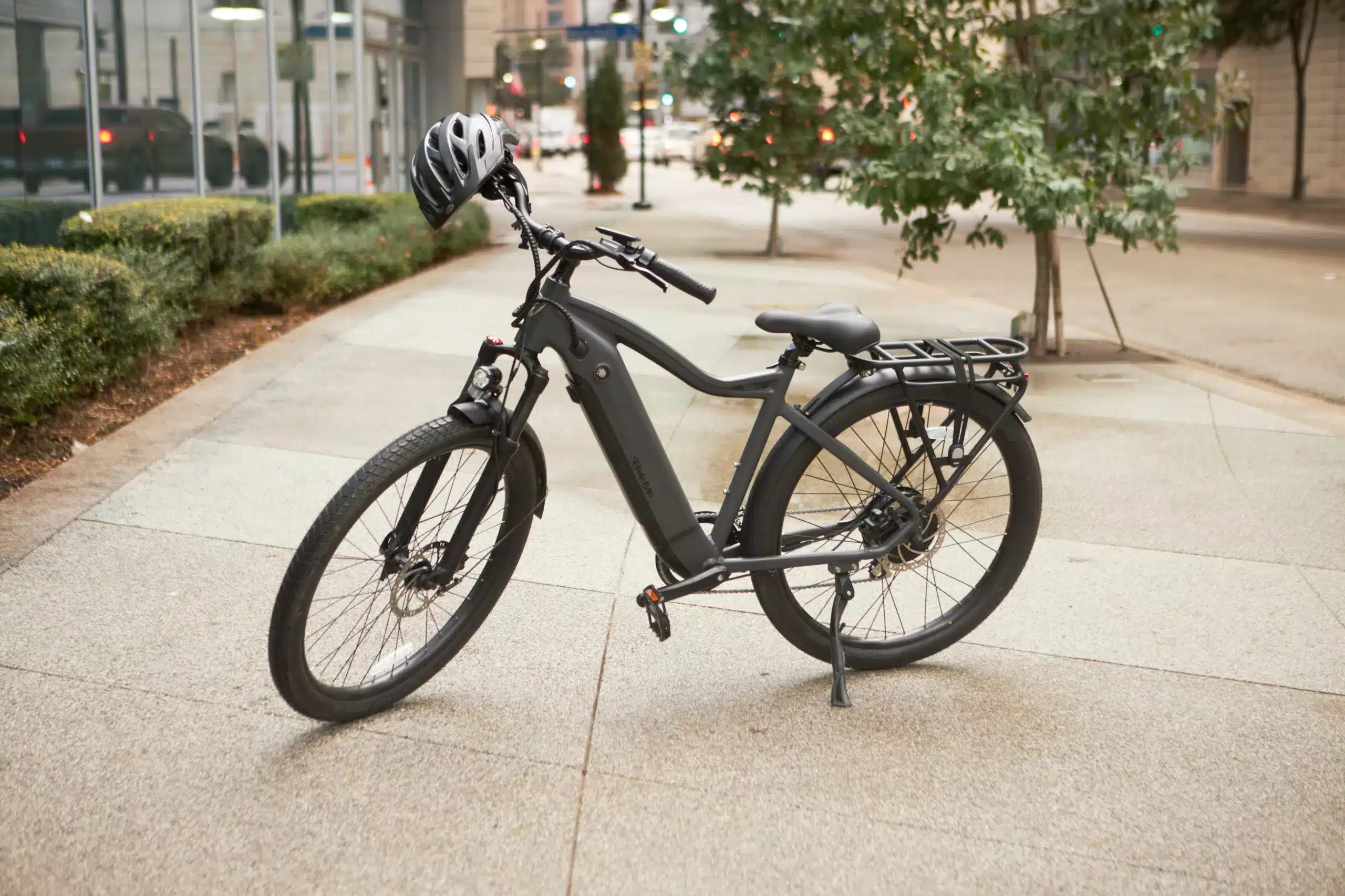 A view of the ride up series class ebike parked on the street with a helmet hung