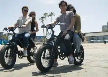 A view of two pair of people riding two seater electric bike