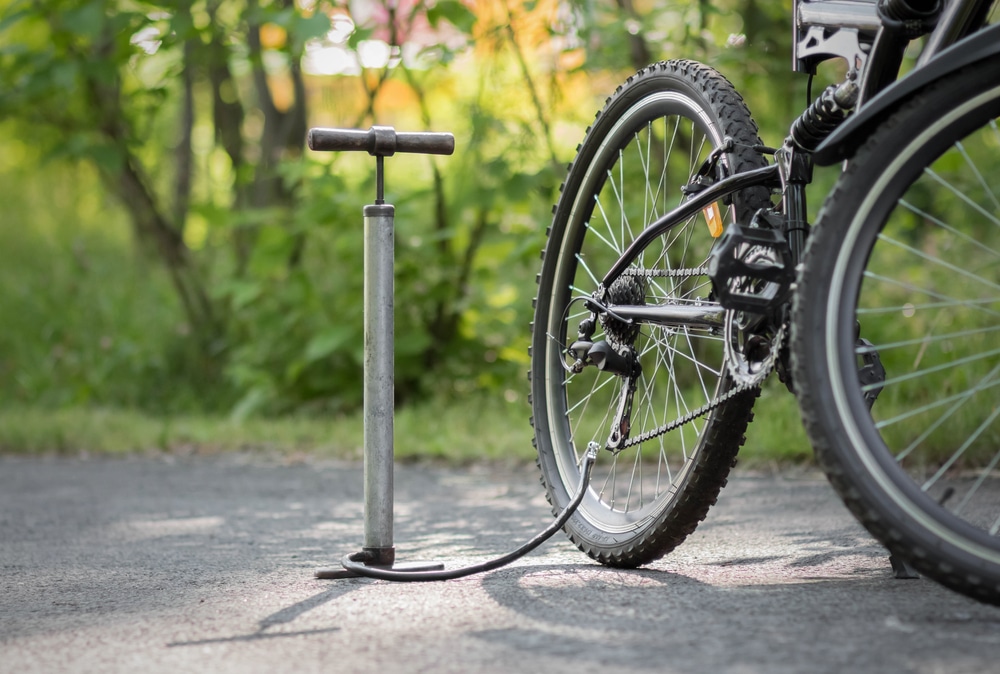 A view of a bike pump alongside a bicycle on road