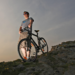 A view of a guy standing at a mountian with a hybrid bike