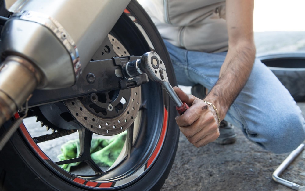 A view of a person changing a bike tire with a wrench