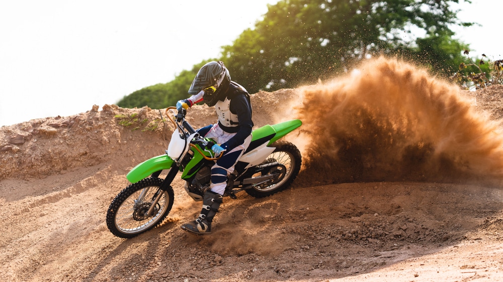 A view of a person racing a dirt bike in mud