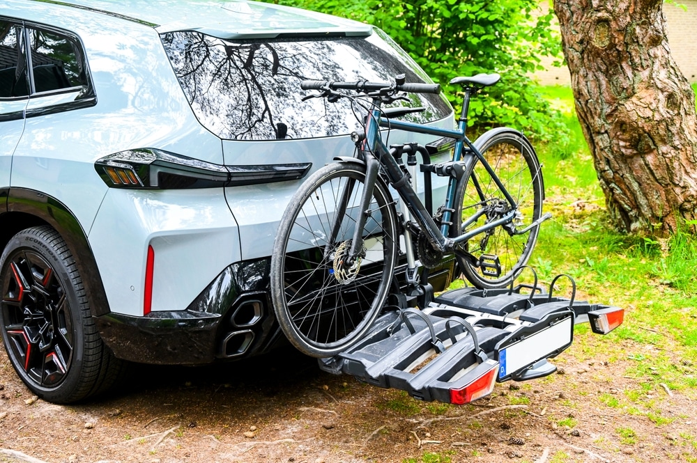 A view of a bike hung over a hitch rack on a car