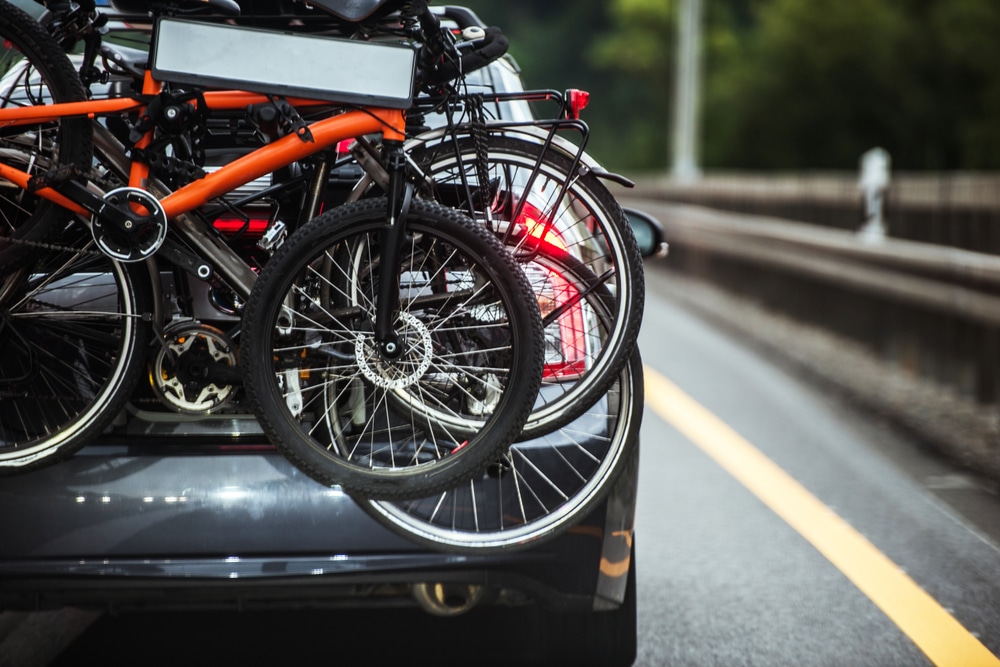 A view of the back of a vehicle carrying bikes on a hitch rack