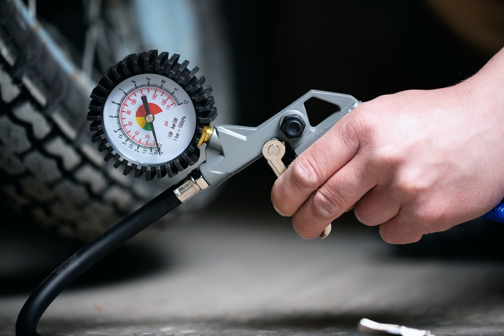 A view of a person inflating a bike pump with a gauge