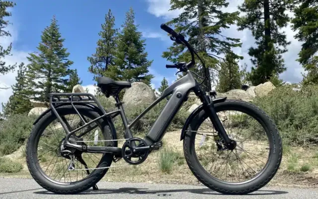 A view of a class ebike parked on a road alongside hills and trees