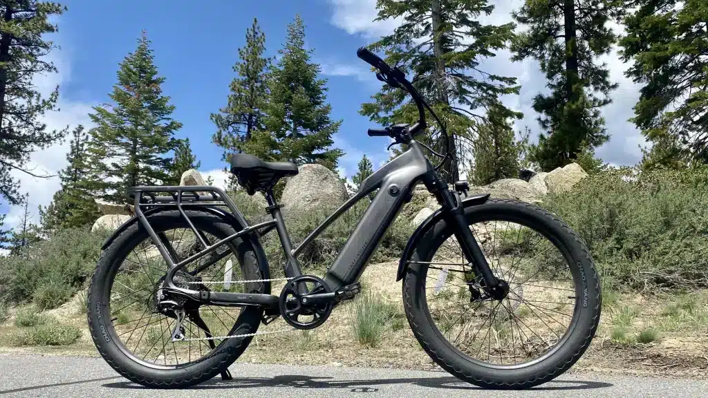 A view of a class ebike parked on a road alongside hills and trees