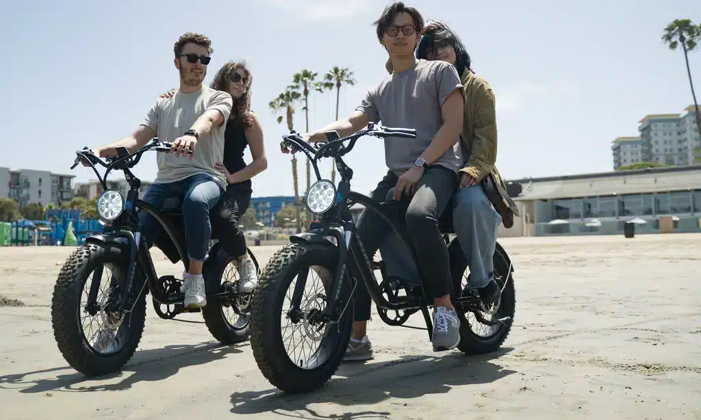 A view of two pair of people riding two seater electric bike
