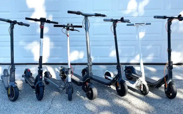 different models of electric scooters parked in a line